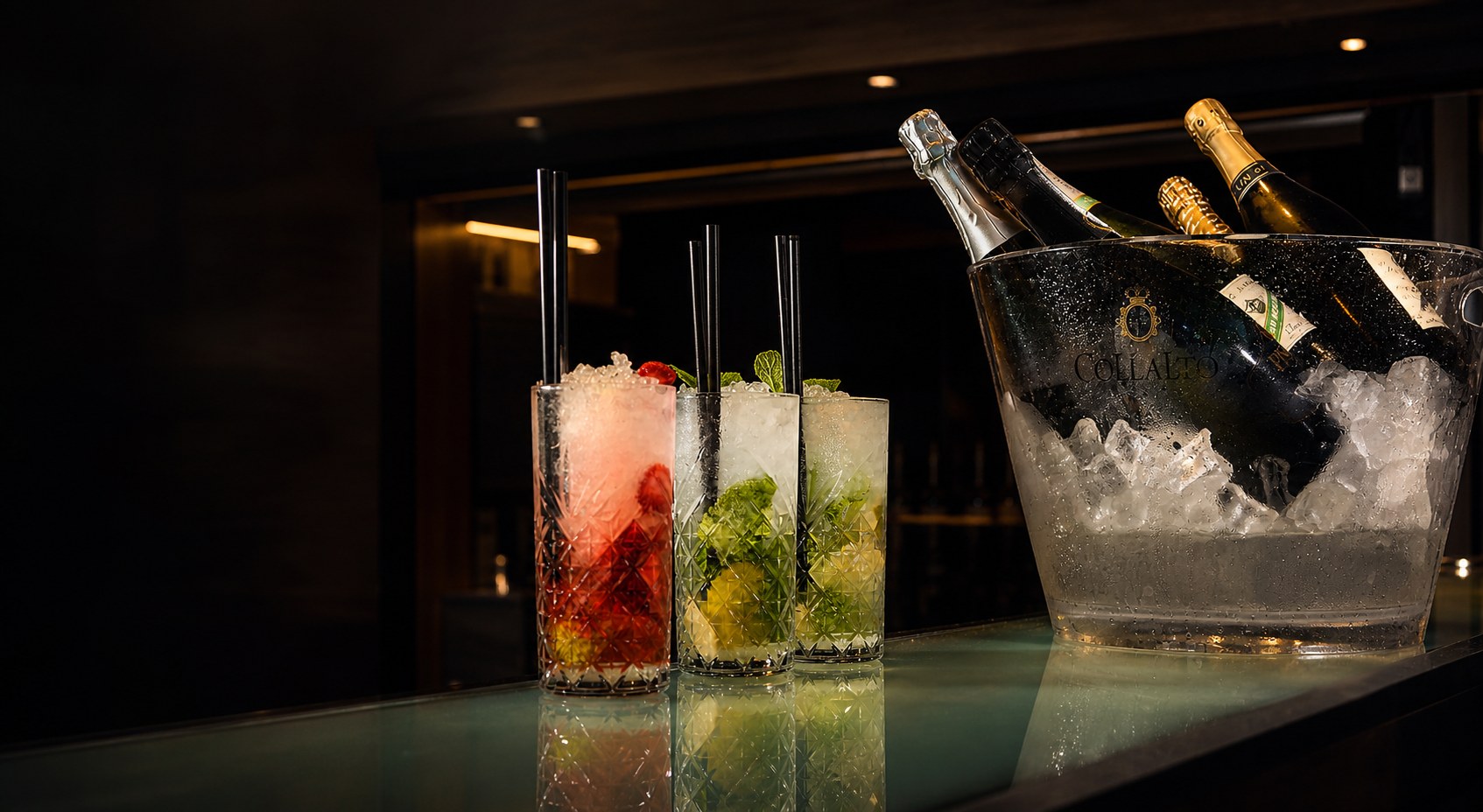 Cocktail e bottiglia di bollicine nel secchiello del ghiaccio